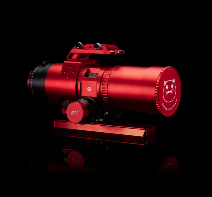 A compact apochromatic refractor telescope with a vibrant red aluminum body. The REDCAT 51 Gen 3 has a cylindrical design with a smooth finish. Its front lens is protected by a matching red cap, with a white cat printed on it.