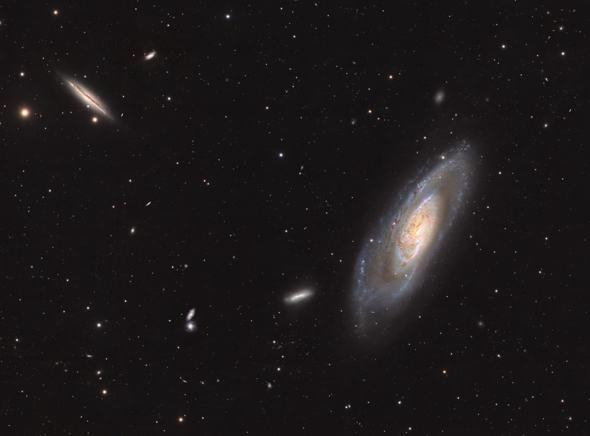 Messier 106, a bright spiral galaxy with well-defined arms and a glowing core, shown alongside NGC 4217, a slightly smaller edge-on spiral galaxy with a thin, elongated shape and visible dust lanes, both captured together against a dark starry background.