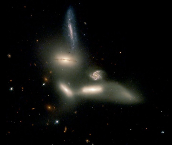 Seyfert’s Sextet, a compact group of six galaxies—four visibly interacting, one background galaxy, and one with a faint tail—captured in sharp detail by NASA’s Hubble Space Telescope.